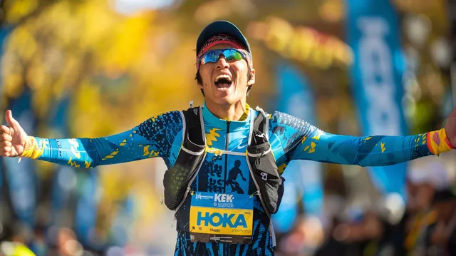 Runner celebrates finishing a race in Hoka gear