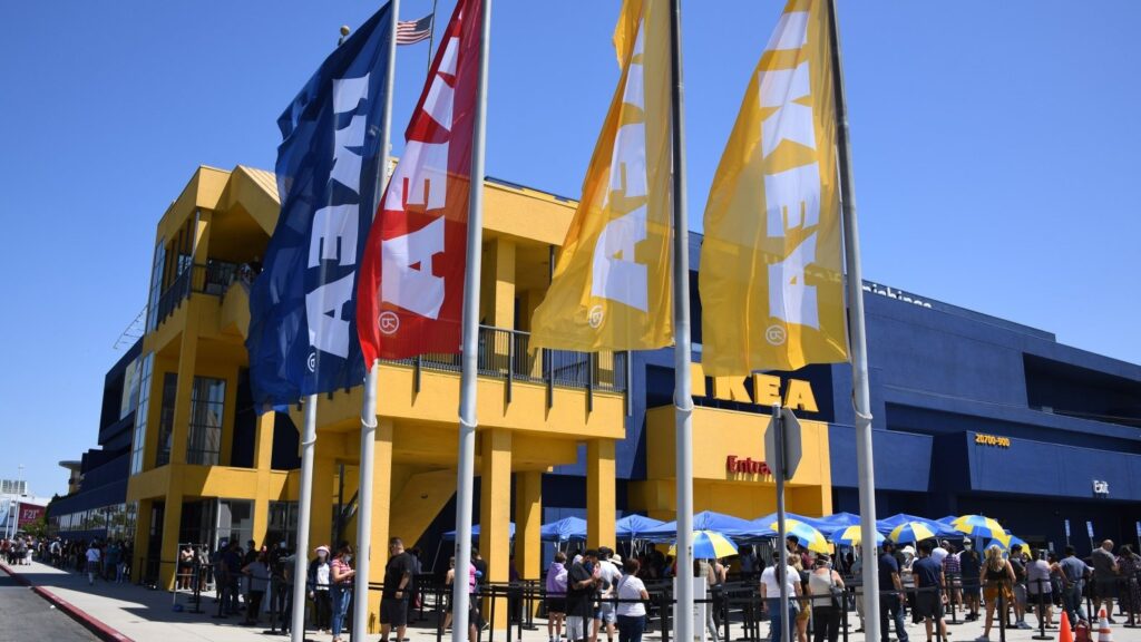 People wearing face masks wait in line to shop at Ikea in Carson